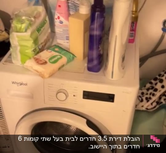 מכונת כביסה עם חומרי ניקוי על גבי המכסה